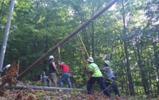 linemen holding up pole