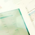 Tablet, pen, and financial documents