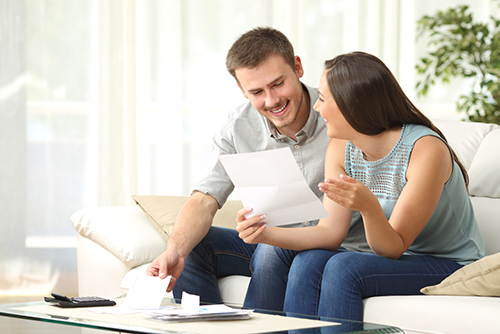 Man and woman smiling while paying bills